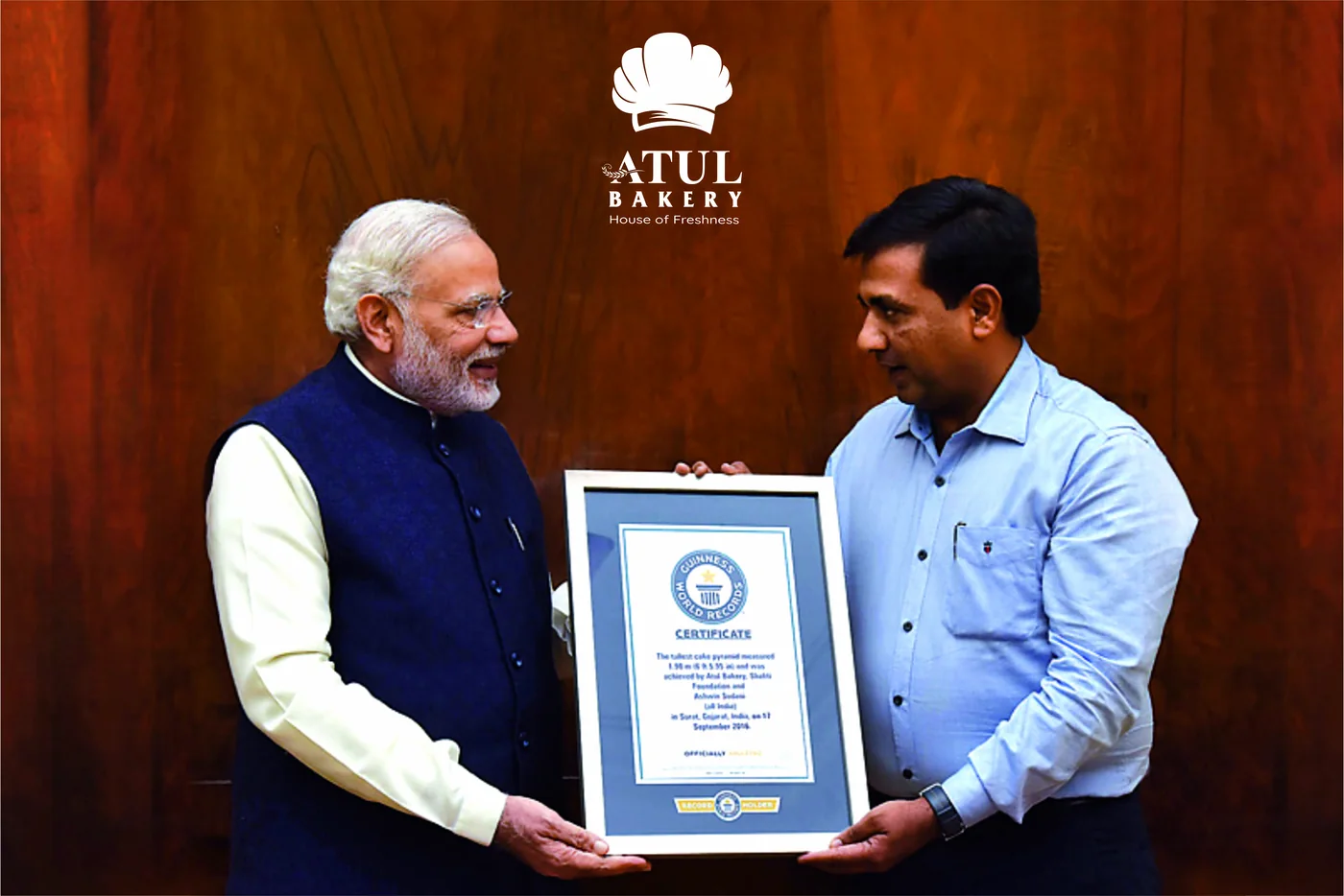 Atul Bakery receiving its Guinness World Records certificate for the world's tallest cake pyramid from Prime Minister Narendra Modi